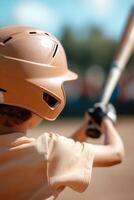 A child in a tan helmet prepares to swing a baseball bat, fully focused as teammates cheer in the background, capturing the thrill of a youth baseball game on a bright afternoon photo