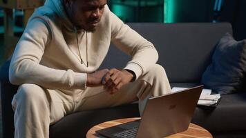 zuversichtlich jung Mann lösen Täglich Aufgaben auf ein freiberuflich Plattform beim heim, antworten E-Mails und Multitasking. Person bleiben in Verbindung gebracht und genießen das Flexibilität von Arbeiten entfernt. Kamera a. video