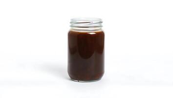 Brewed beverage in a jar with rich texture and deep hue photo