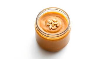 Creamy peanut butter in a jar with roasted peanuts on top photo