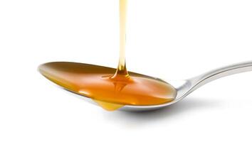 Honey pouring from a jar into a spoon with a smooth, glossy texture photo