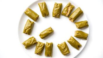 Delicious grape leaf rolls arranged in a circular pattern on a plate photo