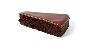 Rich chocolate cake slice with glossy frosting on a plain surface photo