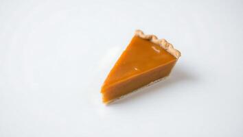Slice of pumpkin pie on a clean plate with a crisp crust and smooth filling photo