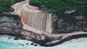 Construction digging and engineering the rock on cliff coastline in Bali. Drone view video