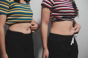 Two women standing next to each other with their stomachs photo