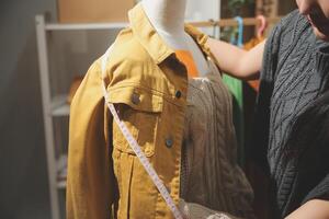A woman is measuring a jacket on a rack photo