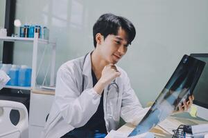 A male doctor is looking at a x - ray image on a computer screen photo
