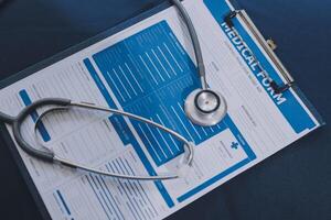 A medical stethoscope is placed on a clipboard with a medical form photo