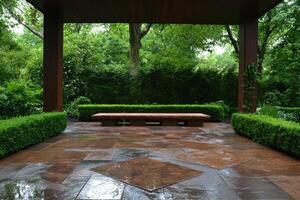 A tranquil outdoor patio with a stone bench surrounded by lush greenery photo