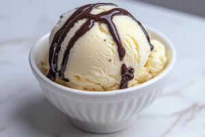 A bowl of vanilla ice cream with chocolate sauce photo