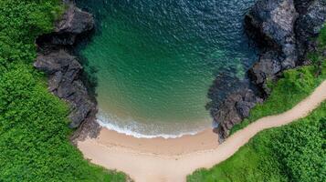 Aerial view of a secluded beach cove with turquoise water and lush greenery photo