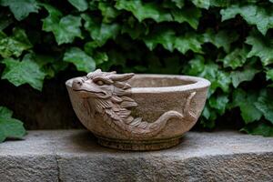 Dragon planter on a stone ledge with ivy in the background photo