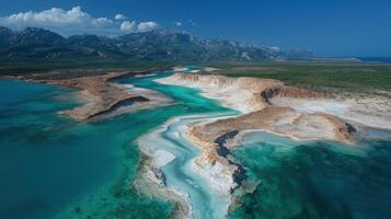 Aerial view of a turquoise river flowing into the sea with mountains in the background photo