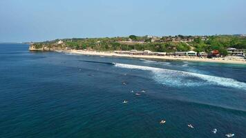 Aerial view of beach with waves and surfers in ocean in Balangan beach, Bali video