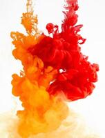 Yellow and red ink in water creating abstract shape, isolated on white background photo