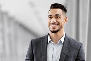 Portrait Of Happy Arab Man With Digital Tablet Standing At Airport Terminal, Handsome Middle Eastern Businessman Using Tab Computer While Waiting For Flight Departure, Enjoying Business Trip photo