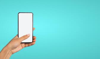Female Hand Holding Phone With Empty White Screen Over Blue Studio Background. Mobile Application Advertisement Mockup. Great App For Your Smartphone. Vertical, Cropped photo