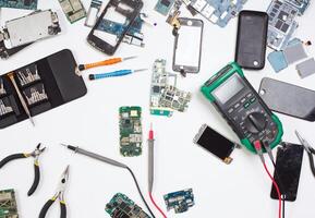 Mobile phone repair flat lay background, top view of workplace at service center. Smartphone disassembling and diagnostics photo