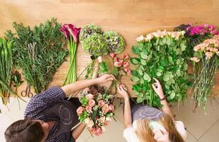 Small business. Flowers delivery top view. Florists creating order, making rose bouquet in flower shop. photo