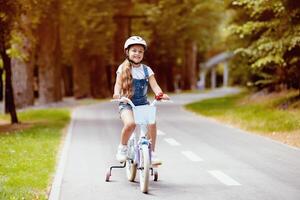 Little Girl Riding Bicycle Wearing Protective Helmet Having Fun In Park Outdoors. Summer Activity For Child. Empty Space For Text photo