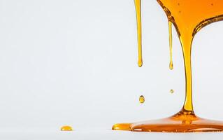 Golden honey trickles down from a container, creating elegant splashes and droplets. photo