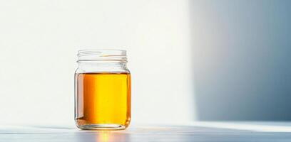 Golden honey fills a glass jar, showcasing the natural color and clarity typical of organic products. This scene captures the essence of beekeeping and the importance of sustainable practices. photo