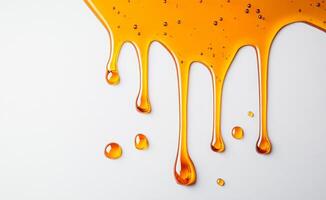 Golden honey drips and splashes across a clean white background, showcasing its rich color and smooth texture. The liquid glistens under soft light, emphasizing its sweet allure and natural beauty. photo