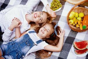 Family Picnic. Happy Mother And Daughter Lying On Plaid In Park Enjoying Summer Day Outside. Above View photo