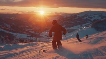 Skiers glide down a snow covered slope while enjoying the breathtaking view of a sunset over the mountains, creating an atmosphere of winter serenity and adventure. photo