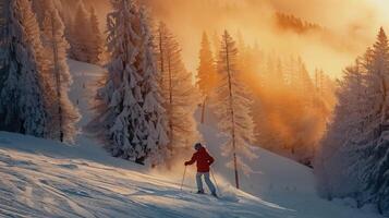 A skier glides down a snowy slope surrounded by frost covered trees, illuminated by a stunning sunset creating a warm orange glow in the sky. photo