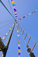 Mast and sail rolled-up with colorful flag photo