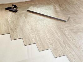 SPC Wood Floor Being Installed in a Herringbone Pattern. photo