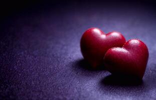Two red hearts on dark purple background in Valentines Day style with empty space for text. photo