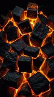 Smoldering coal cubes with sparks from fire, glowing with intense orange and red hues photo