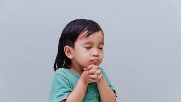 Asian boy praying to God with hands held together with people stock photo