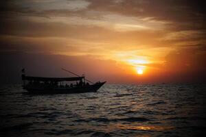 a boat is sailing in the ocean at sunset photo