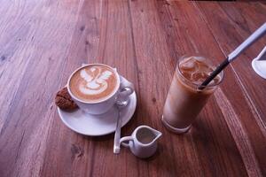 a cup of coffee and a cookie on a wooden table photo