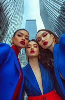Three women in blue and red suits posing for a photo