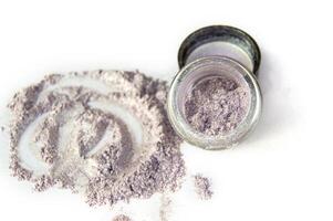 A small amount of purple powder is sitting on top of a white surface photo