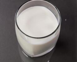 A glass of milk on a black surface photo
