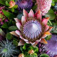 This arrangement displays a mesmerizing blend of large blooms and greenery, highlighting intricate textures and rich colors photo