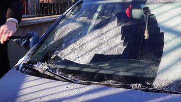 Man scraping ice from the windshield video