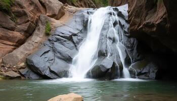 Serene Waterfall Cascading Over Dark Rocks into a Calm Pool photo