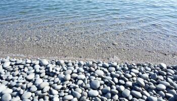 Smooth Gray Pebbles on a Clear Blue Sea Shore photo