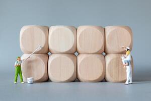 Miniature Painters at Work on Wooden Blocks on grey background photo