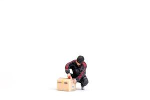 A Miniature figurine of a delivery worker carrying packages Concept of service and reliability in a creative photo