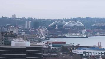 Aerial view of Seattle's downtown skyline featuring skyscrapers, steam rising from buildings, cloudy skies, and surrounding hills and trees. video