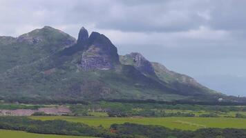 Aerial view showcasing vibrant green fields, dense vegetation, and steep forested mountains on Kauai Island with a slow, sweeping motion. video