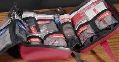 A red first aid kit on a wooden table highlights emergency readiness video